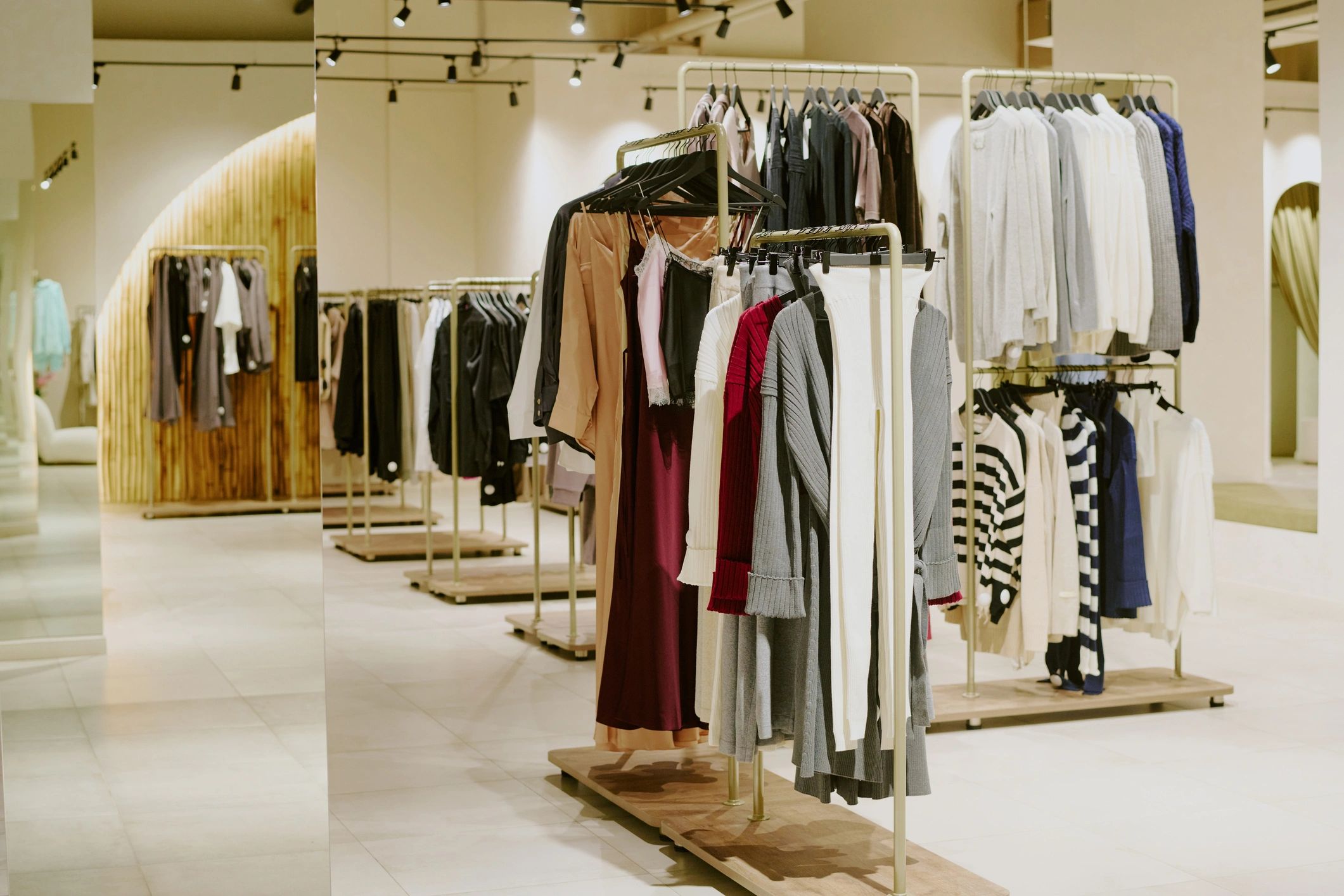 Designer outfits displayed on hangers in a premium boutique