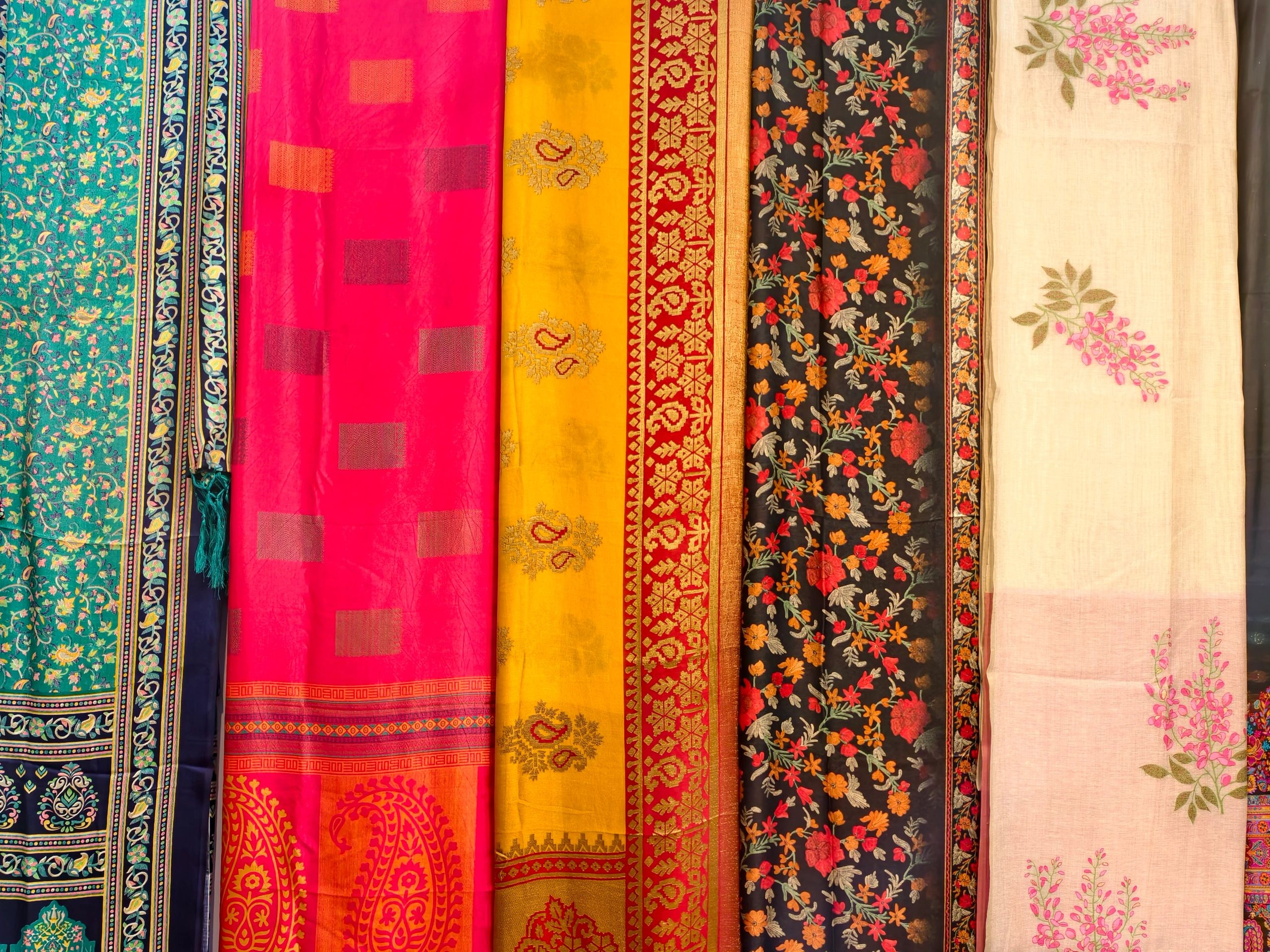 Stacked colorful sarees in a retail display